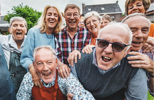 Joyful Seniors Taking a Group Selfie - Over-65 friends gathered at a countryside house, laughing and shouting together while capturing a festive moment.