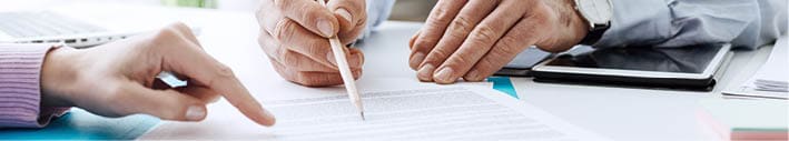 Business people negotiating a contract, they are pointing on a document and discussing together