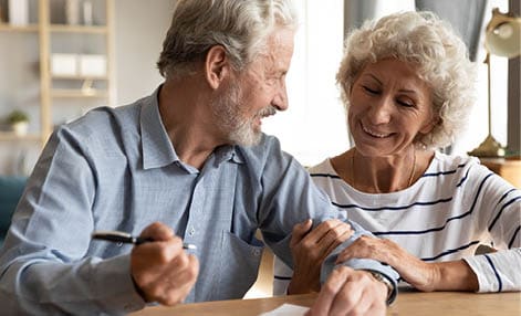 70s couple sit at table indoor discuss agreement term and condition feels satisfied make financial deal ready to sign contract, bequeath savings and property to their children or grandchildren concept